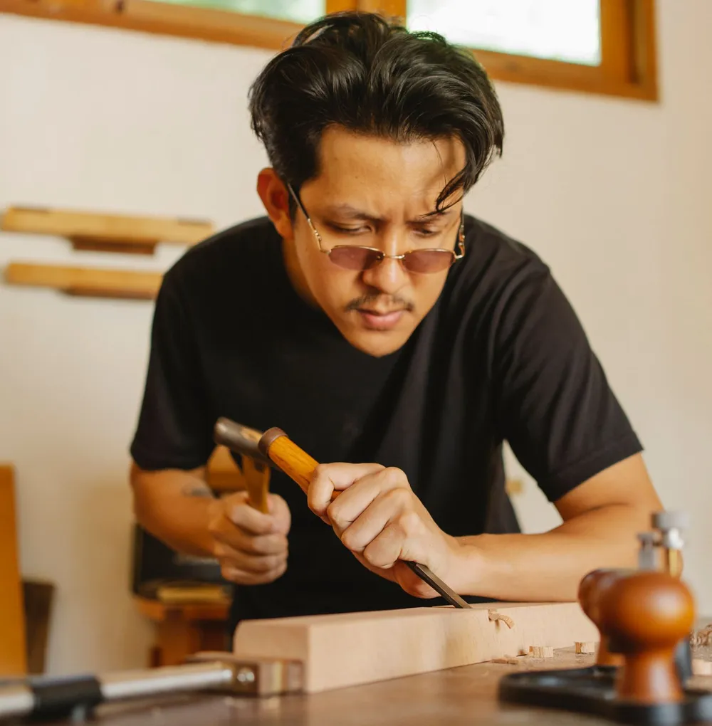 Thợ mộc dùng đục và búa tạo mộng trên phôi gỗ